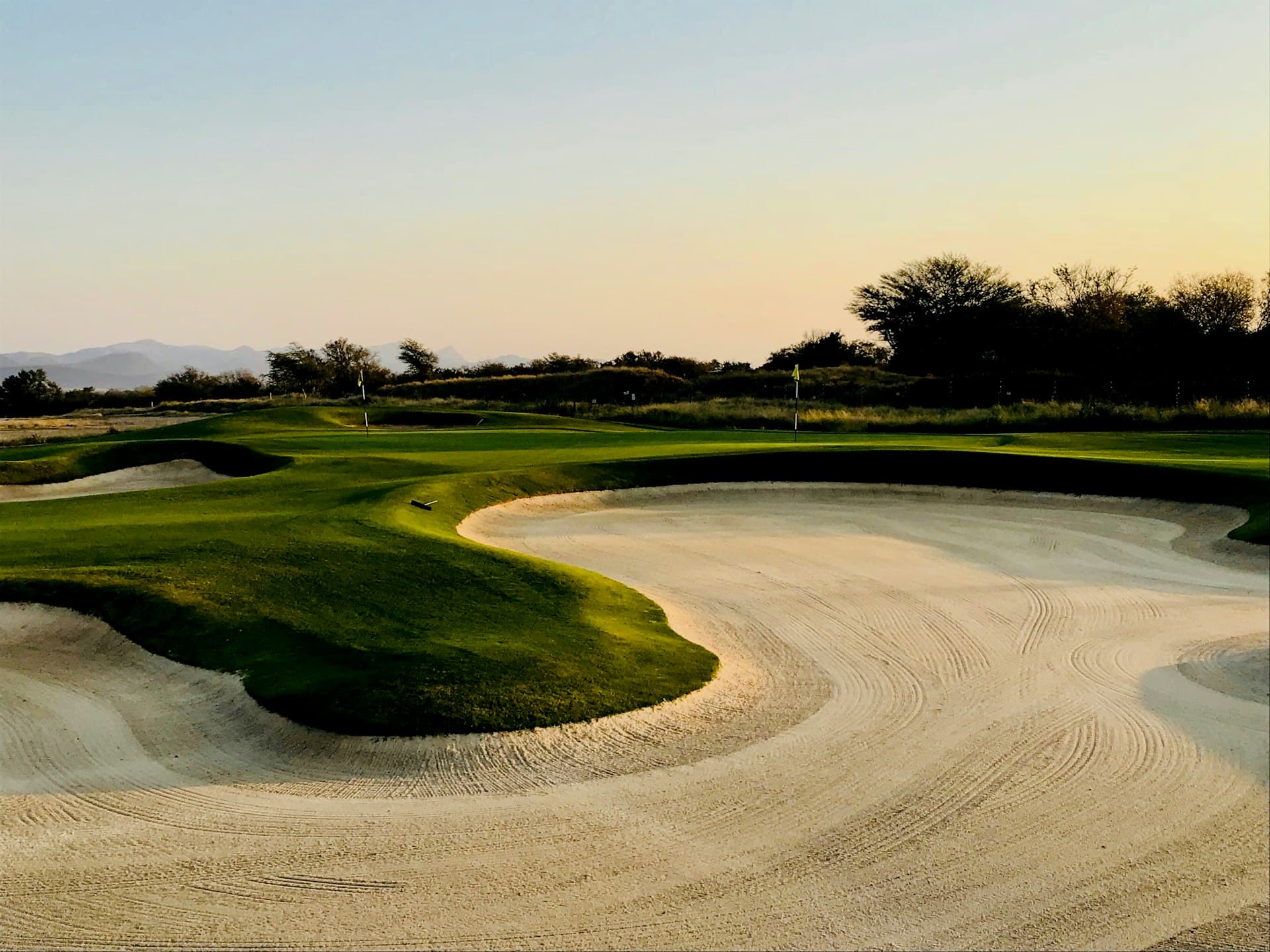 Manicured golf course bunkers at dusk